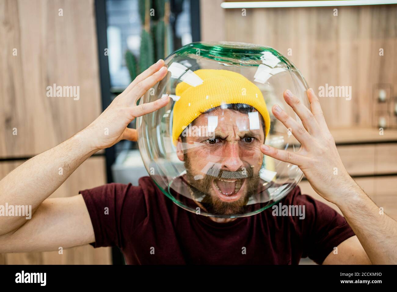 Frustrierter Geschäftsmann, der im modernen Büro Fishbowl trug Stockfoto