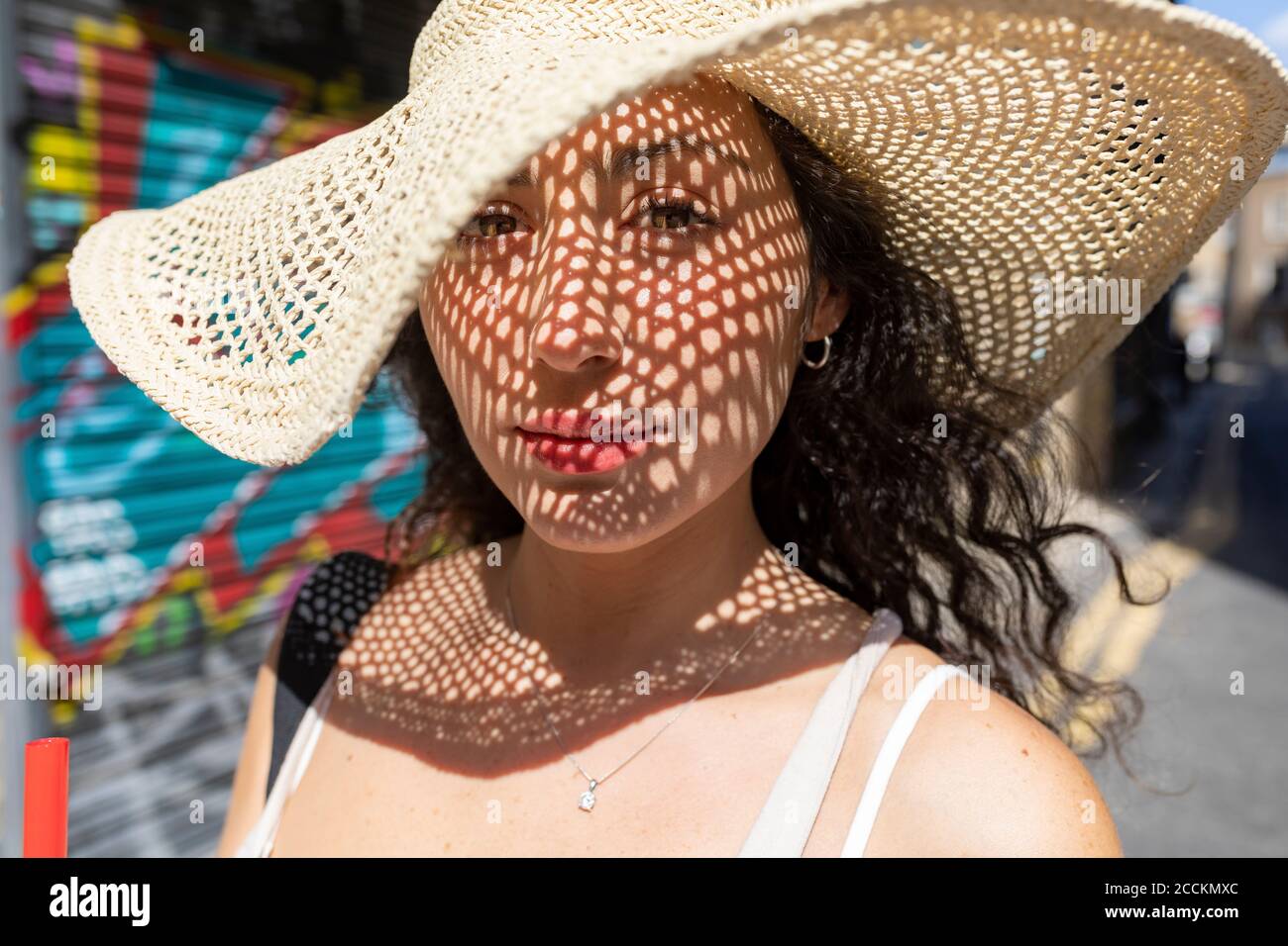 Nahaufnahme einer schönen Frau mit Hut in der Stadt bei Sonnenschein Tag Stockfoto