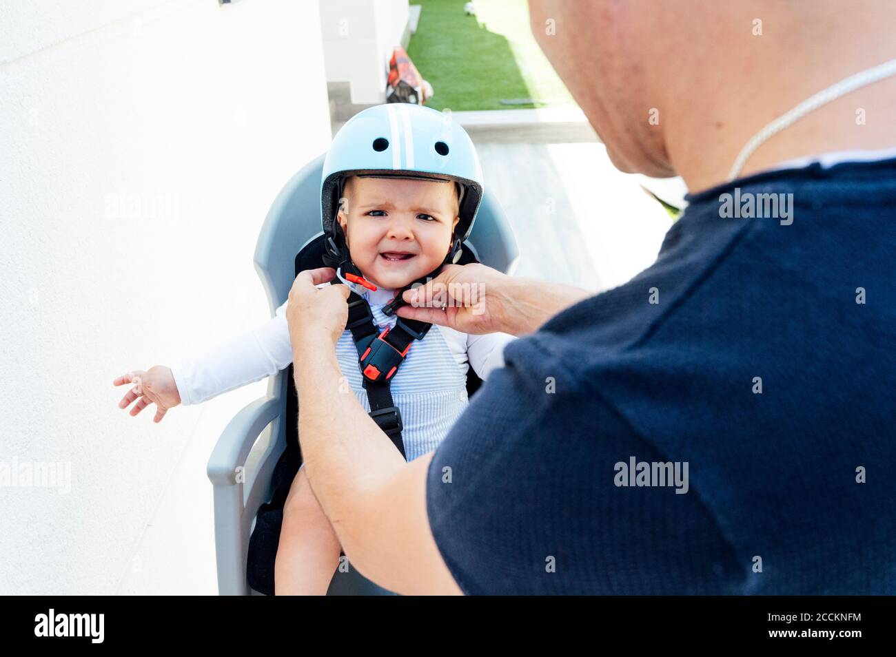 Vater mit Sohn sitzt in der Sicherheit Sitz des Fahrrads Stockfoto