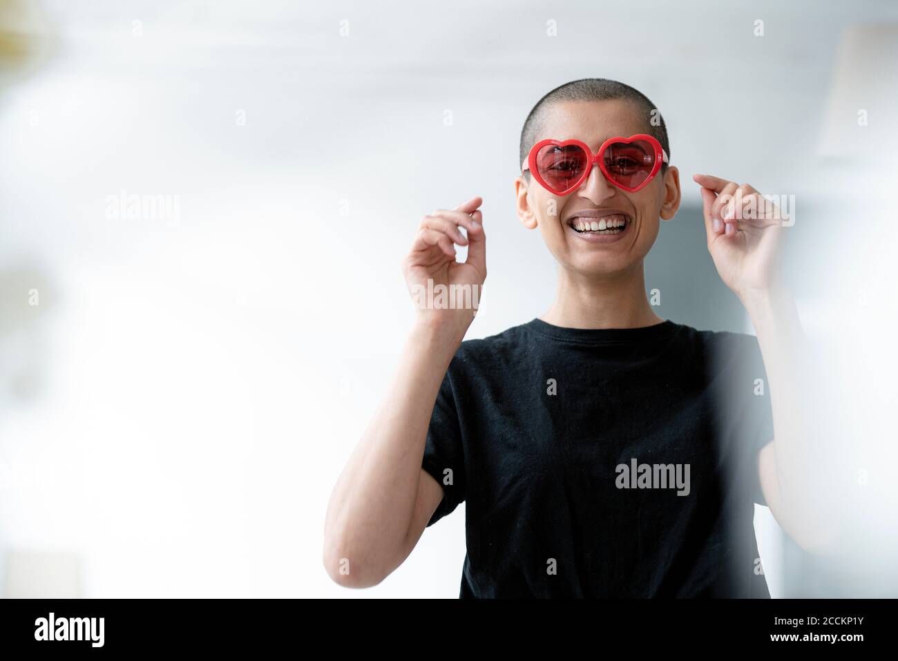 Porträt einer fröhlichen Frau mit herzförmiger Sonnenbrille Stockfoto