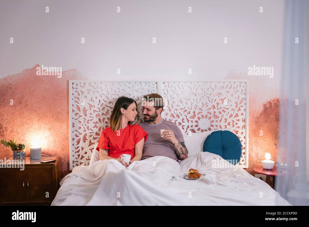 Romantisches Paar mit Frühstück auf dem Bett zu Hause Stockfoto