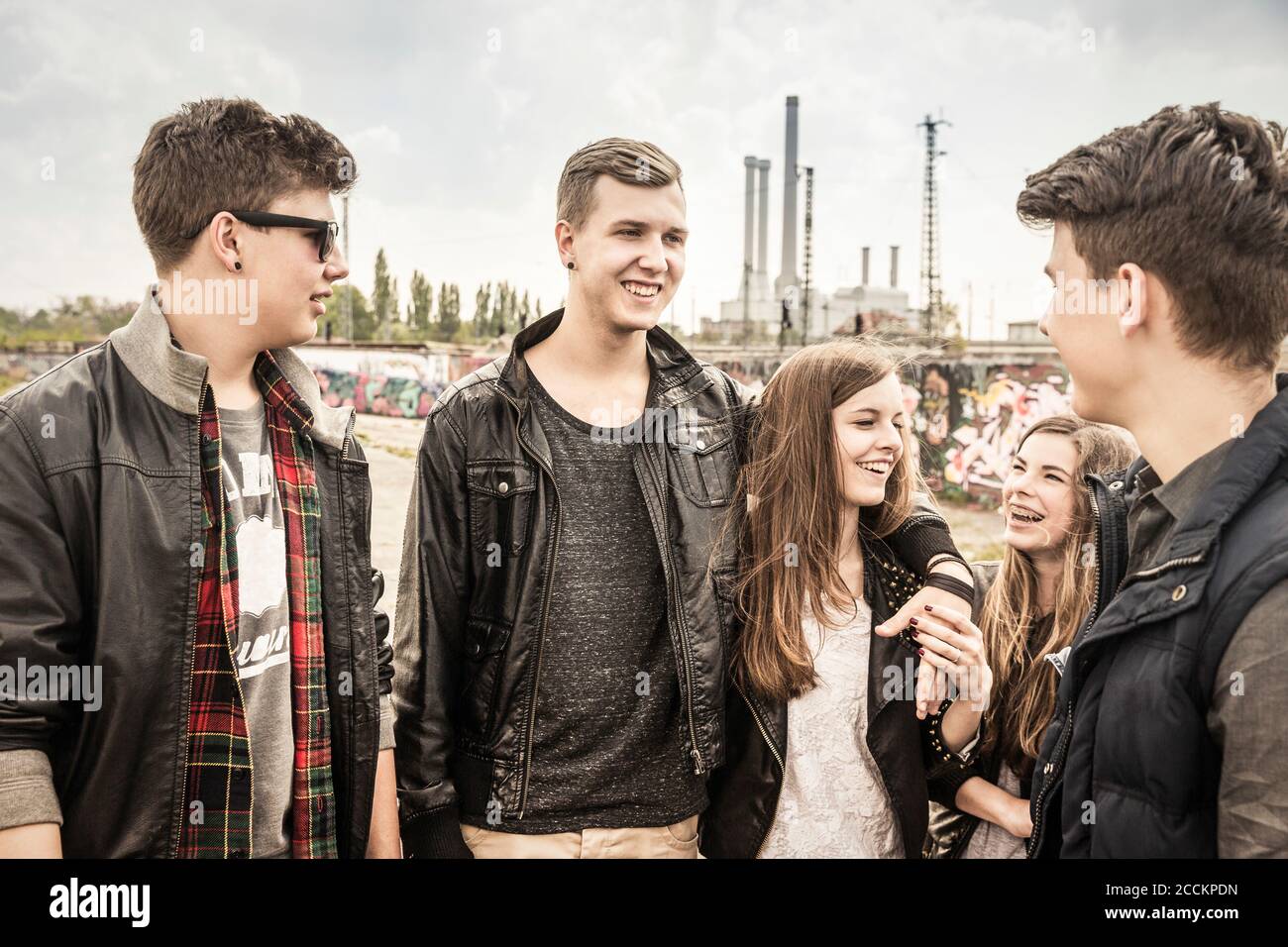 Eine Gruppe von Freunden, die in einem alten heruntergekommenen Hotel rumhängen Industriegebiet Stockfoto
