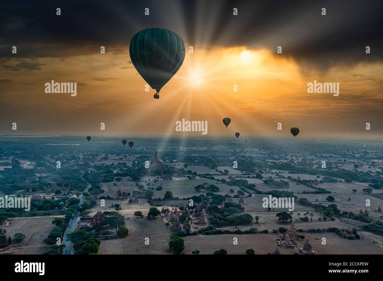 Myanmar, Mandalay Region, Bagan, Heißluftballons fliegen über alte Stupas bei dramatischem Sonnenaufgang Stockfoto