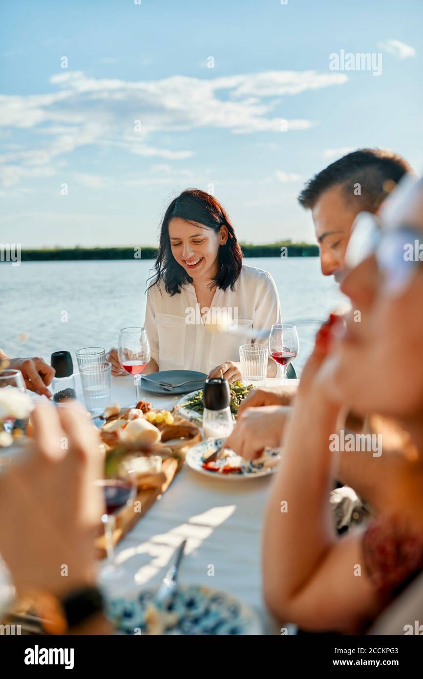 Freunde, die an einem See zu Abend essen Stockfoto