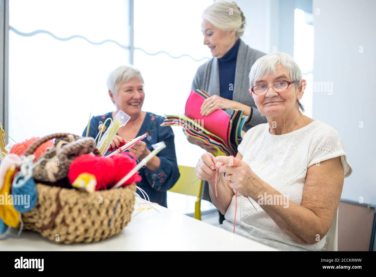 Ältere Frauen Stricken zusammen in Nadelarbeit Gruppe der Altersheim Stockfoto