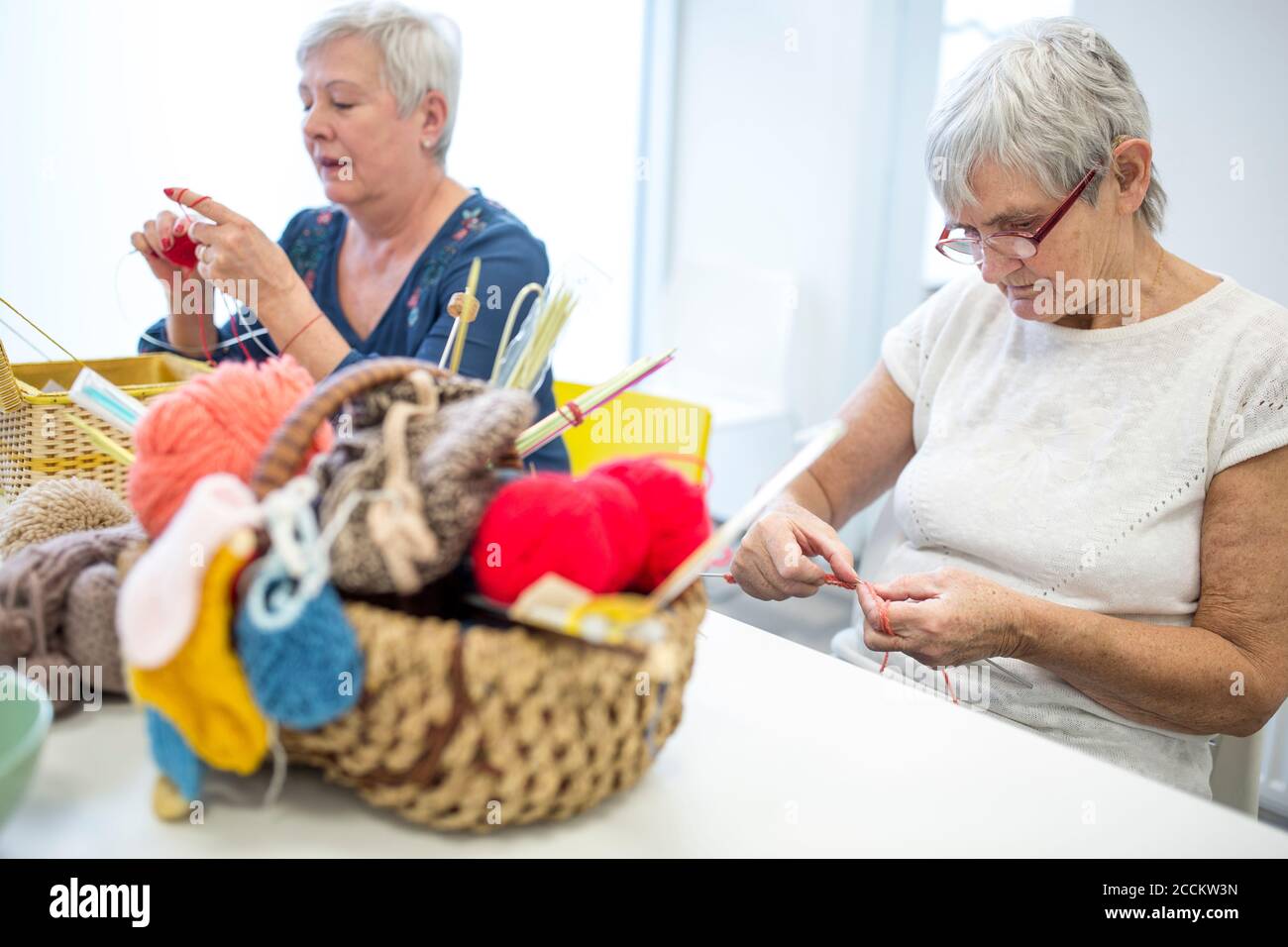 Ältere Frauen Stricken zusammen in Nadelarbeit Gruppe der Altersheim Stockfoto