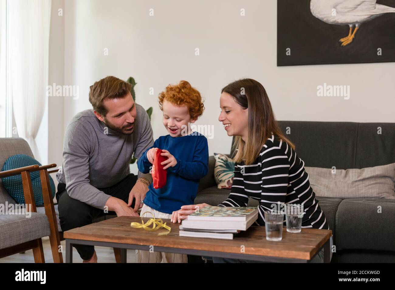 Niedlicher Junge zeigt Spielzeug Roboter lächelnde Eltern im Leben Zimmer zu Hause Stockfoto