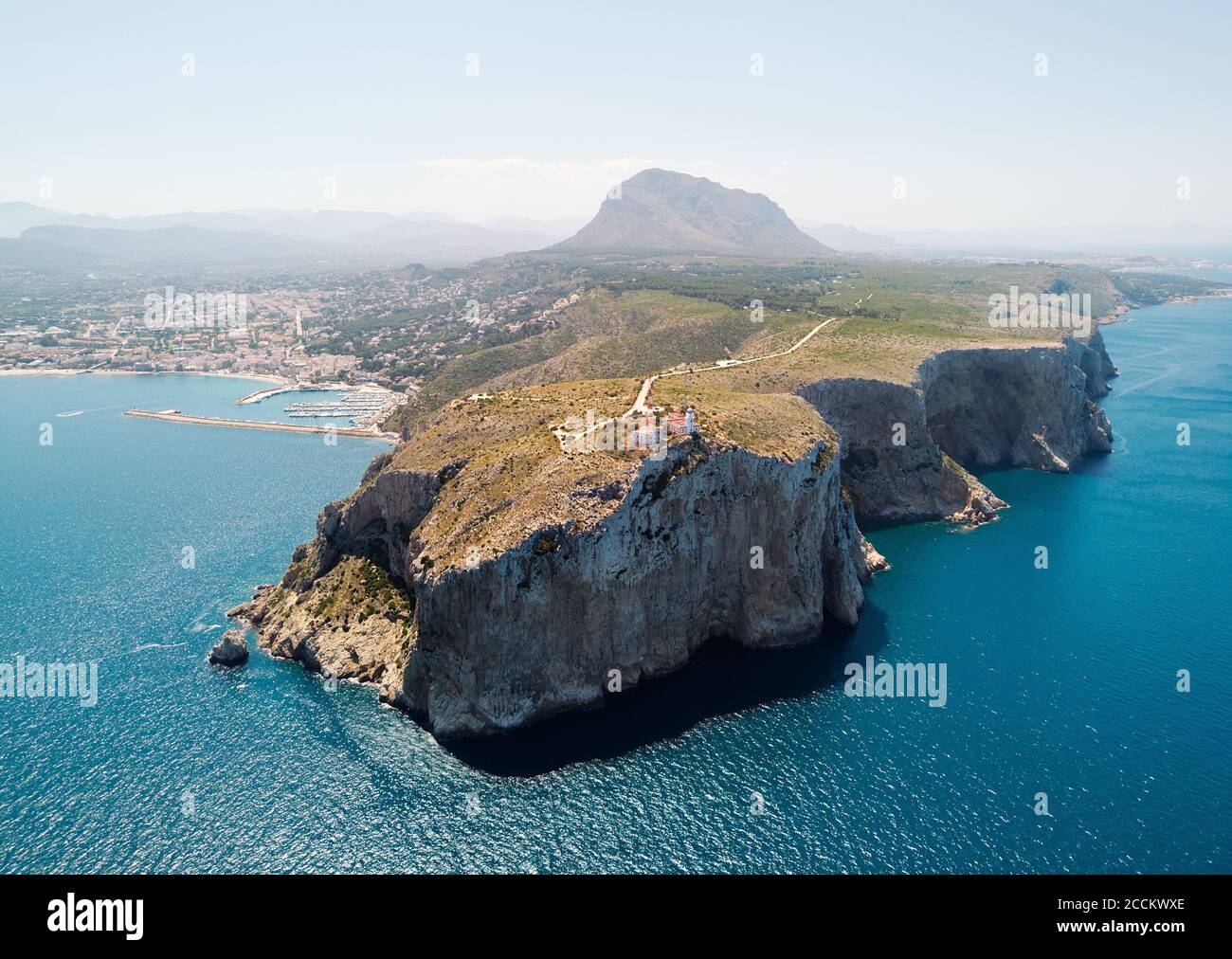 Luftaufnahme Fotografie Küstenstadt Javea mit grünen felsigen Bergen, türkisfarbene Bucht Mittelmeer verankerte Schiffe im Hafen, Comarca von Marina Stockfoto