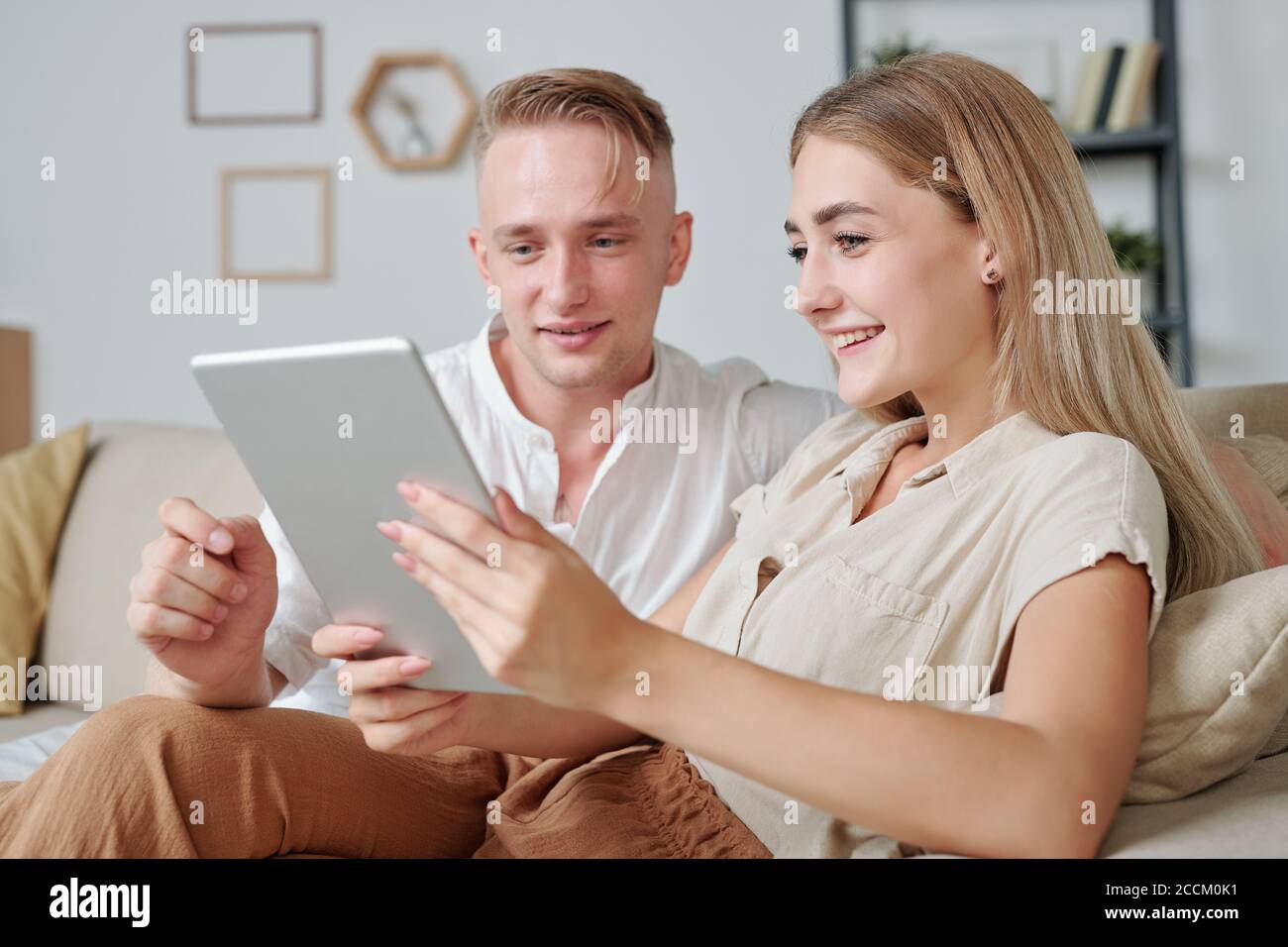Zeitgenössische junge liebevolle Paar mit Tablet, um Online-Video zu sehen Stockfoto