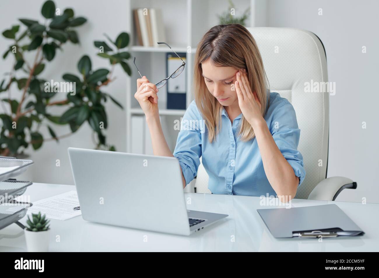 Junge müde Frau mit Kopfschmerzen berühren Tempel und leicht biegen Vorwärts Stockfoto