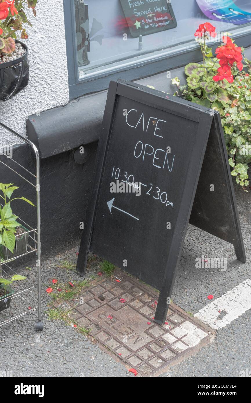 UK Post-Covid Lockdown, A Cafe zeigt seine reduzierten Öffnungszeiten onan A-Frame Kreidetafel / Tafel. Zurück zum normalen, post-covidischen Großbritannien. Stockfoto