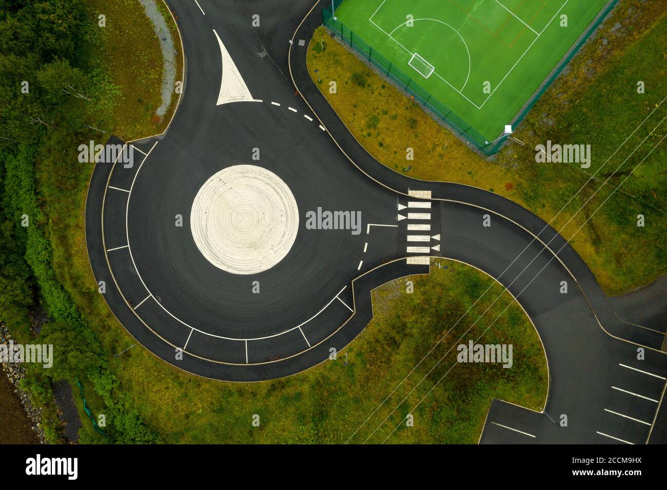 Luftaufnahme von Straßenmarkierungen an einem Kreisverkehr / Parkplatz in der Nähe des Sportkomplexes in Portree, Isle of Skye, Schottland. Stockfoto