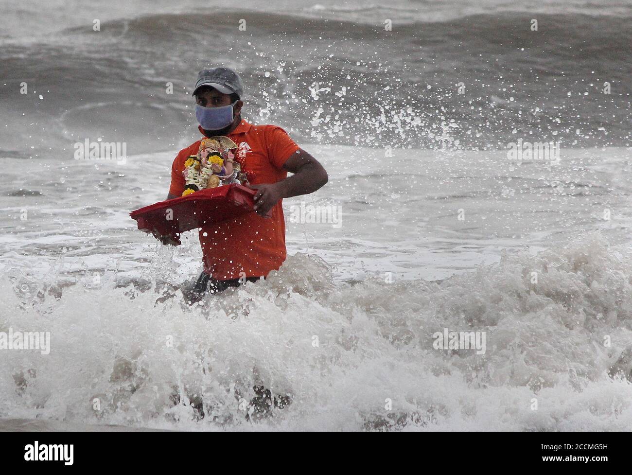 Ein Mann versucht, die Idole des Elefantenköpfigen Hindu-gottes Ganesh während des Festivals vor Wellen zu schützen.aufgrund der Coronavirus-Pandemie haben Freiwillige, die von der städtischen Behörde ernannt wurden, das Eintauchen von Ganpati-Idolen gemacht, damit das göttliche Bewusstsein weit und breit reicht, damit viele Menschen davon profitieren, Ein ritueller Teil des Ganesh Chaturthi Festivals. Stockfoto