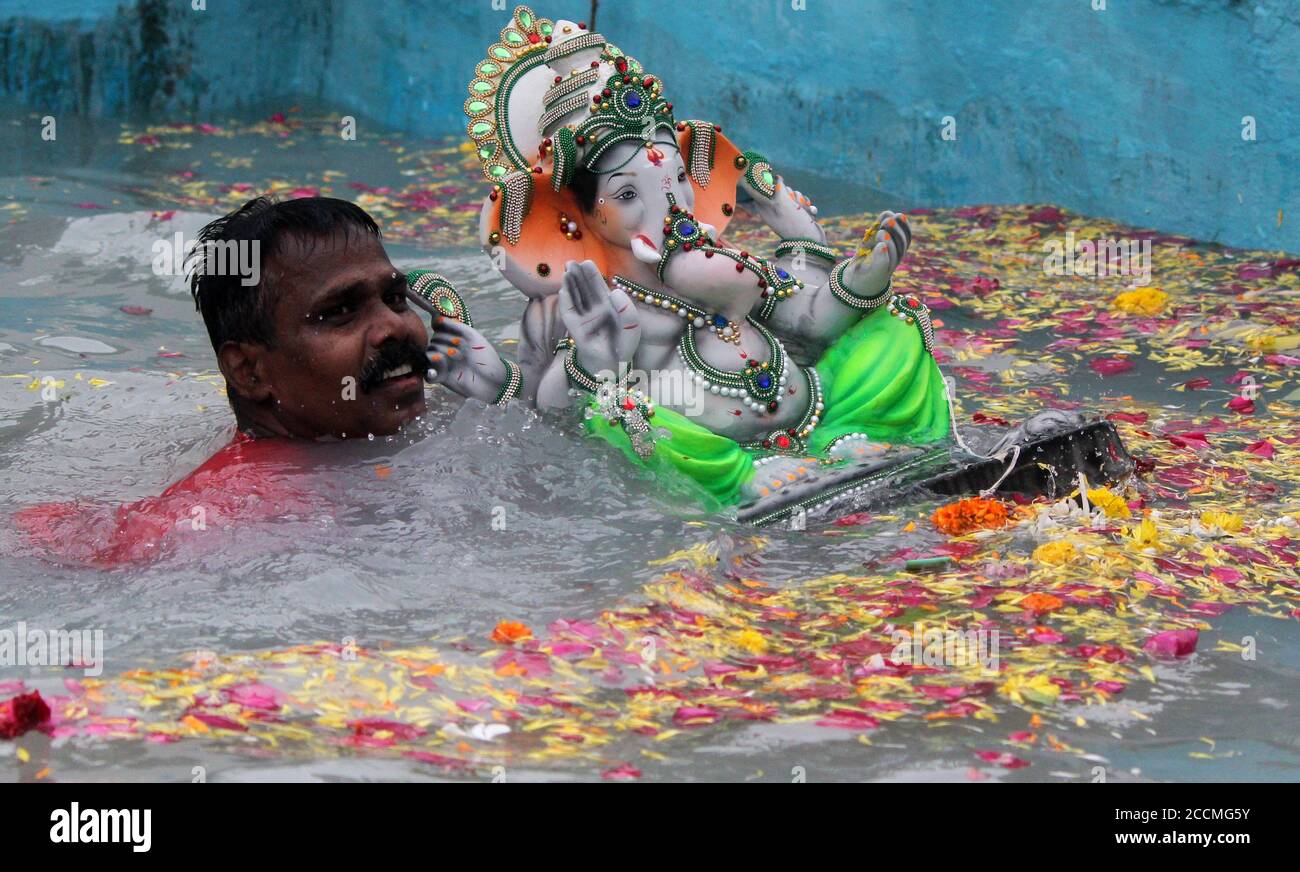 Ein Mann, der während des Festivals ein Ganpati-Idol in einen künstlichen Teich eintauchte.aufgrund der Coronavirus-Pandemie machten Freiwillige, die von der Gemeindebehörde ernannt wurden, das Eintauchen von Ganpati-Idolen, damit das göttliche Bewusstsein für viele Menschen weit und breit reicht, ein ritueller Teil des Ganesh Chaturthi-Festivals. Aufgrund der Coronavirus-Pandemie machten Freiwillige, die von der Gemeindebehörde ernannt wurden, das Eintauchen von Ganpati-Idolen, damit das göttliche Bewusstsein weit und breit für viele Menschen zum Nutzen reicht, ein ritueller Teil des Ganesh Chaturthi-Festivals. Stockfoto