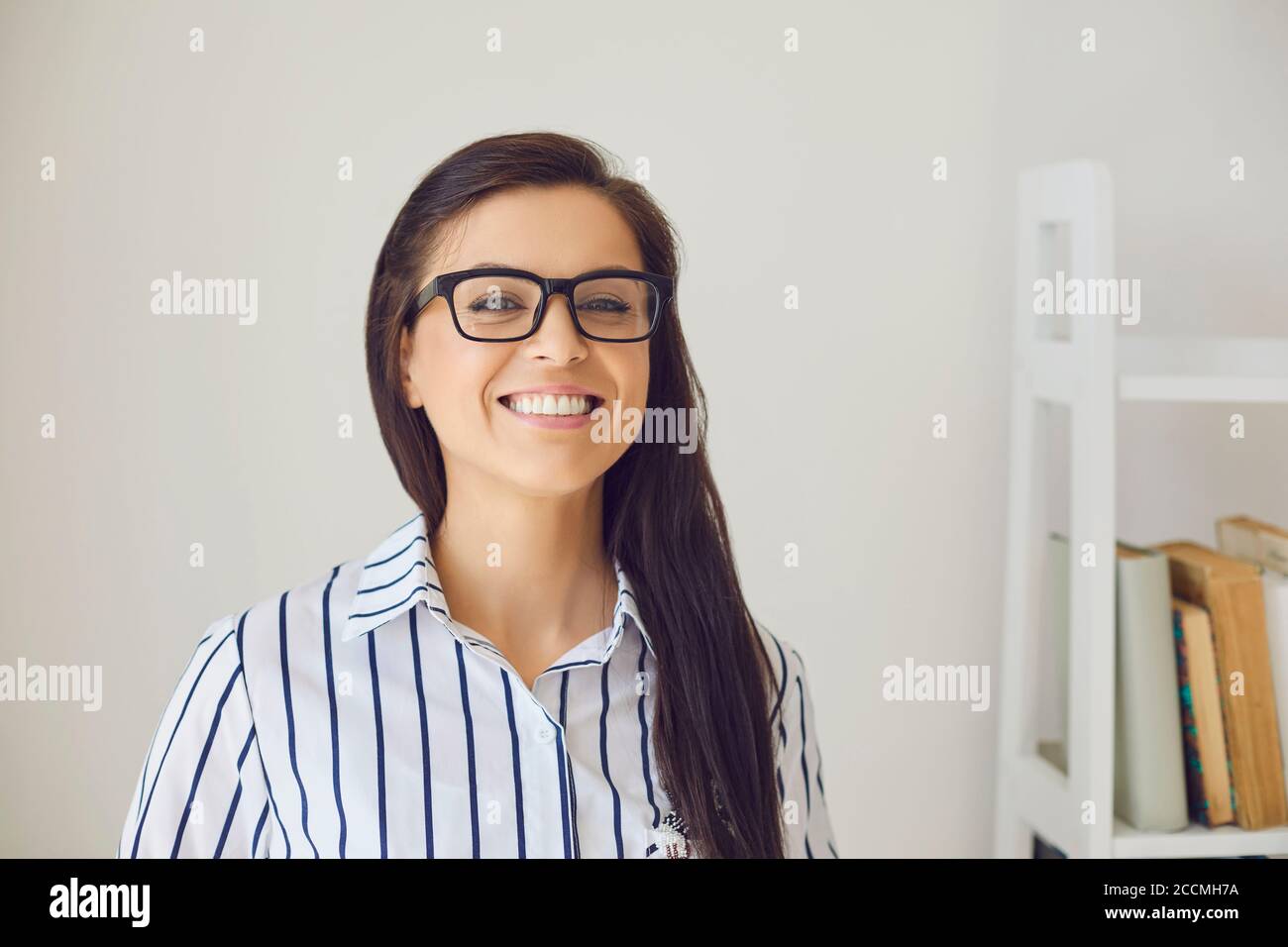 Kopfschuss Frau Lehrer positiv lächelnd sagt Blick auf die Kamera im Zimmer. Stockfoto
