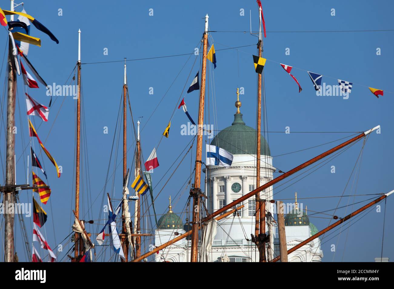 Seezeichen-Flaggen auf Masten von Segelbooten gegen die Kuppel der Kathedrale von Helsinki während des traditionellen Segeltages in Helsinki, Finnland Stockfoto