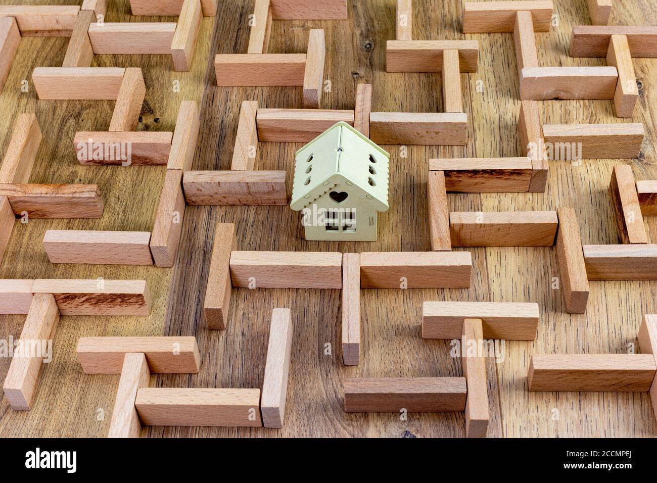 Immobilienkonzept, Holzmaze Modell mit Haus in der Mitte Stockfoto