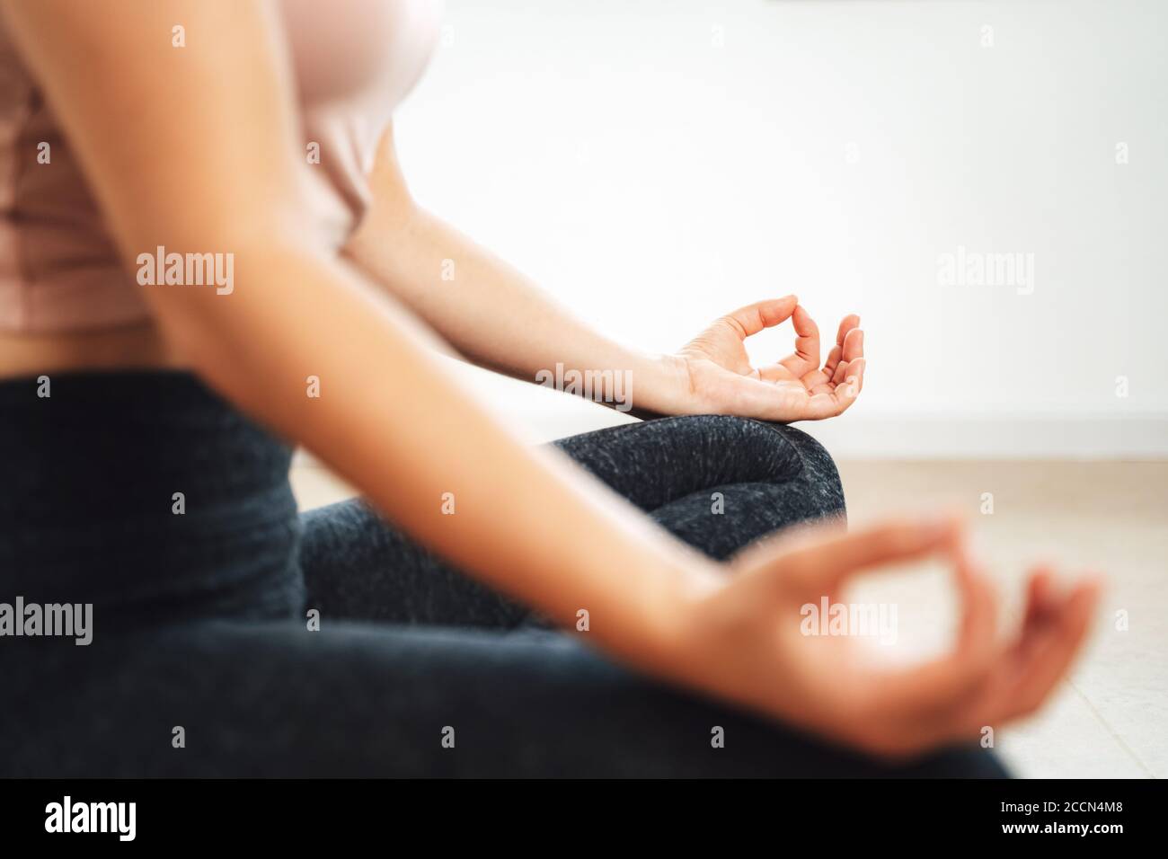Nahaufnahme Hände der jungen sportlichen Frau Praxis Meditation in lotus-Position zu Hause Stockfoto