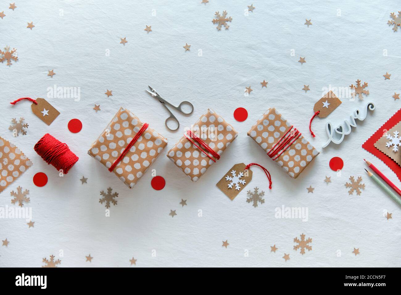 DIY Weihnachtsgeschenke und handgemachte Dekorationen. Kunststoff kostenlos geringe Auswirkungen Weihnachten Feier. Geschenkschachteln n Handwerk Geschenkpapier mit roten Baumwollkordel gebunden. Stockfoto