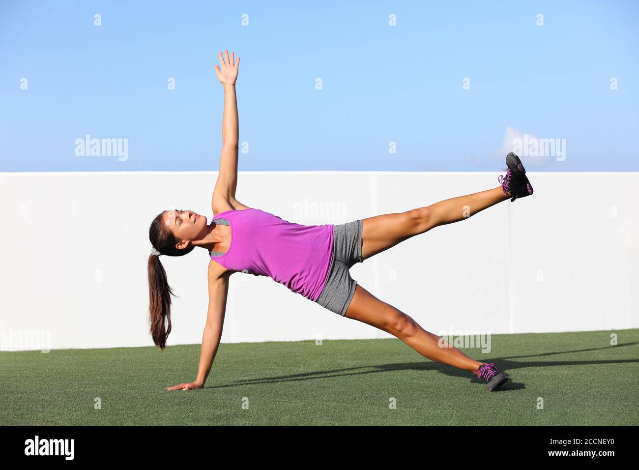 Yoga Frau Planken tun Seite Plank Bein heben Kernübung in Fitness-Gym-Klasse. Asiatische Mädchen Training Seite Plank Bein heben Körperkern in Yoga-Studio auf Stockfoto