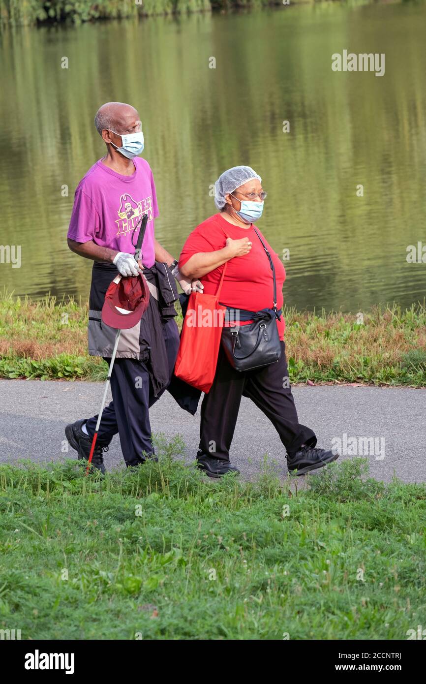 Ein blinder Mann und sein Begleiter auf einem frühmorgendlichen Übungsspaziergang in der Nähe des Sees im Kissena Park, Queens, New York City. Stockfoto