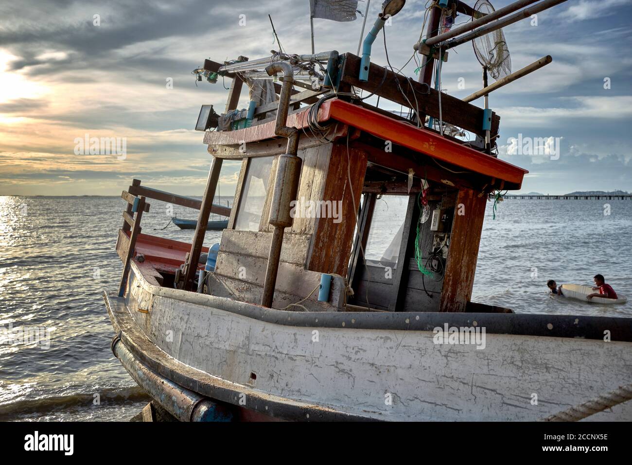 Thailand Fischerboot für den Abend vor einer untergehenden Sonne Hintergrund befahren. Stockfoto