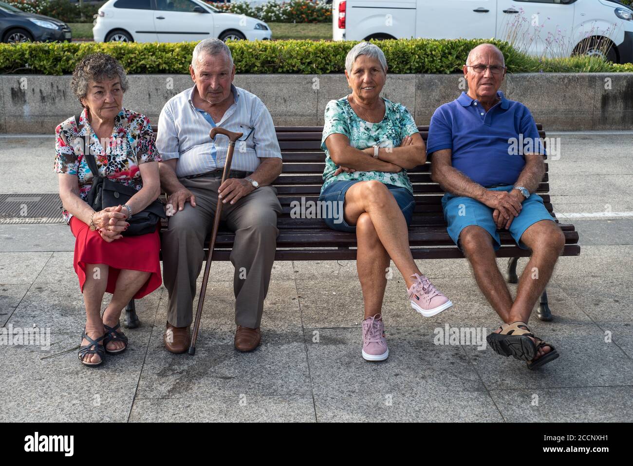 Ältere Leute chillen auf einer Holzbank in Santander, Spanien. Ältere Paare, die sich an einem Sommertag im Freien entspannen Stockfoto Ältere Leute chillen auf einer Holzbank in Santander, Spanien. Ältere Paare, die sich an einem Sommertag im Freien entspannen Stockfoto