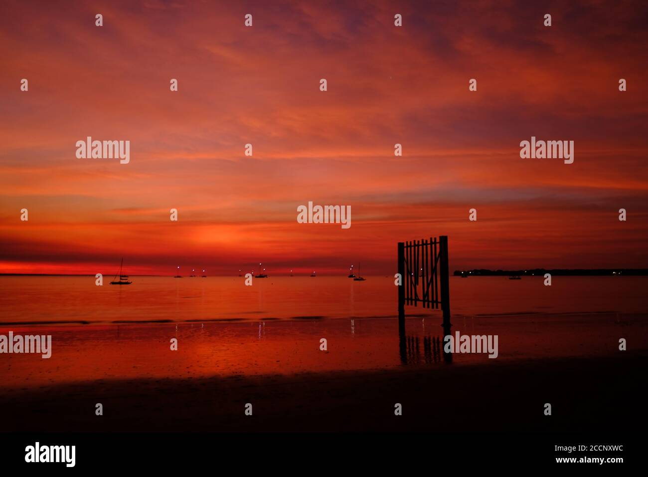 Intensiver, eindrucksvoller Sonnenuntergang mit orangen und roten Farben, Minuten nachdem sich die Sonne versteckt hatte. Vesteys Beach, Darwin Segelclub, Northern Territory, Australien Stockfoto