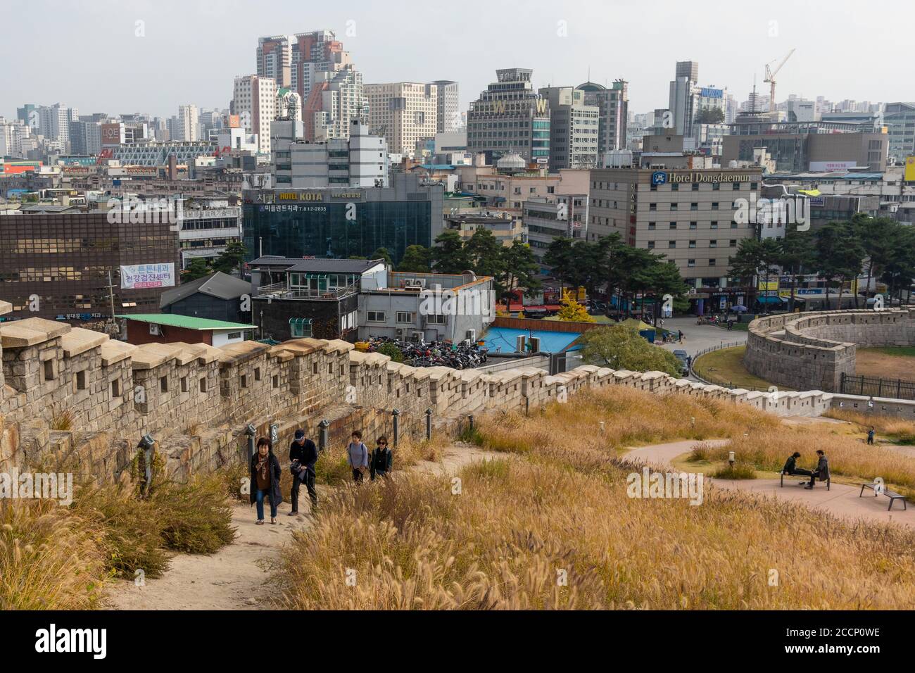 Stadtspaziergang entlang einer alten Mauer, die zur alten Festung der Stadt gehört. Wolkenkratzer und moderne Gebäude. Menschen gehen. Seoul, Korea Stockfoto