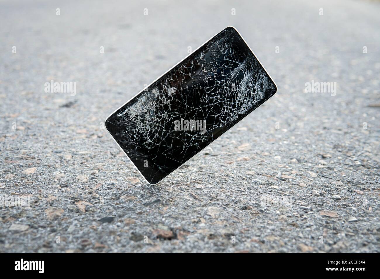 Kaputt, zerstört, ruiniert modernes Handy, Handy, Handy, Telefon. Kaputte, rissige Folie und Schäden. Gerät zerstört. Mobiltelefon Stockfoto