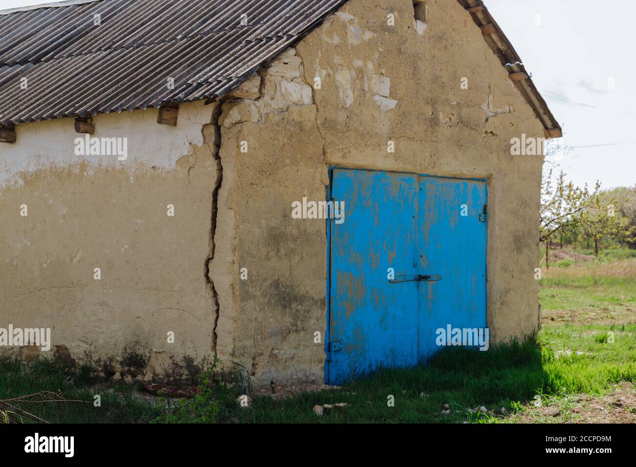 Ein großer gefährlicher Riss in der Wand des Hauses. Das Haus zerstören, den Alarmzustand. Wohnungsprobleme Stockfoto