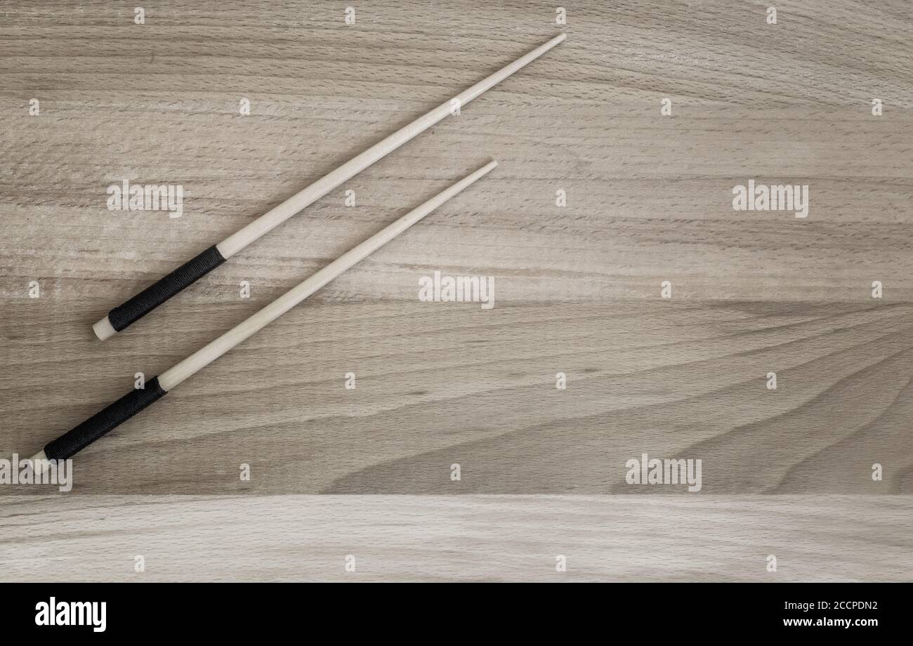 Zwei Holzstäbchen auf einem Holztisch Stockfoto