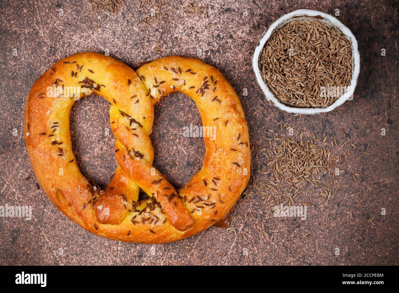 Frisch gebackene hausgemachte Pretzel mit Kreuzkümmel oder Kümmel Samen und grobes Meersalz. Deutscher (bayerischer) Biervorspeise. Selektiver Fokus Stockfoto