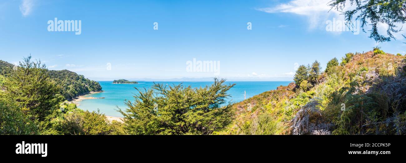 Türkisfarbenes Wasser trifft auf weiße Strände und Regenwälder im Abel Tasman National Park. Palmen und Baumfarne dominieren den Wald, bewaldete Inseln können b Stockfoto