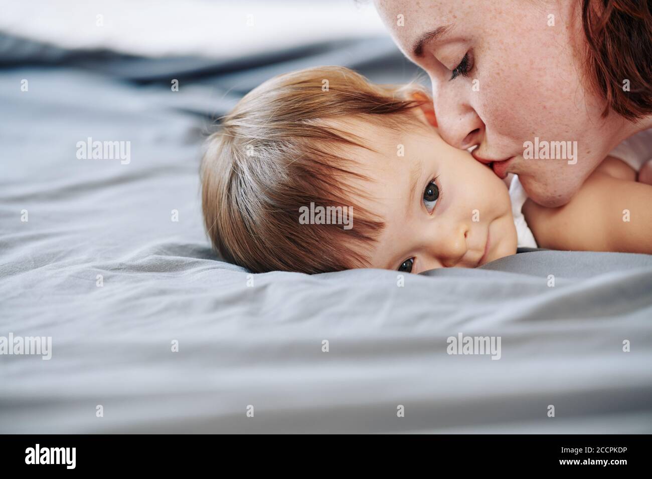Mutter küssen Tochter auf Wange Stockfoto