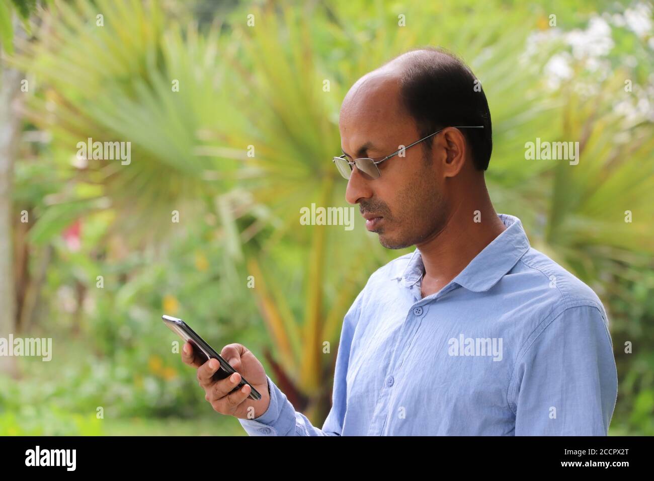 Casual Asian Mann mit Smartphone, lesen Nachrichten auf Handy-Bildschirm Stockfoto