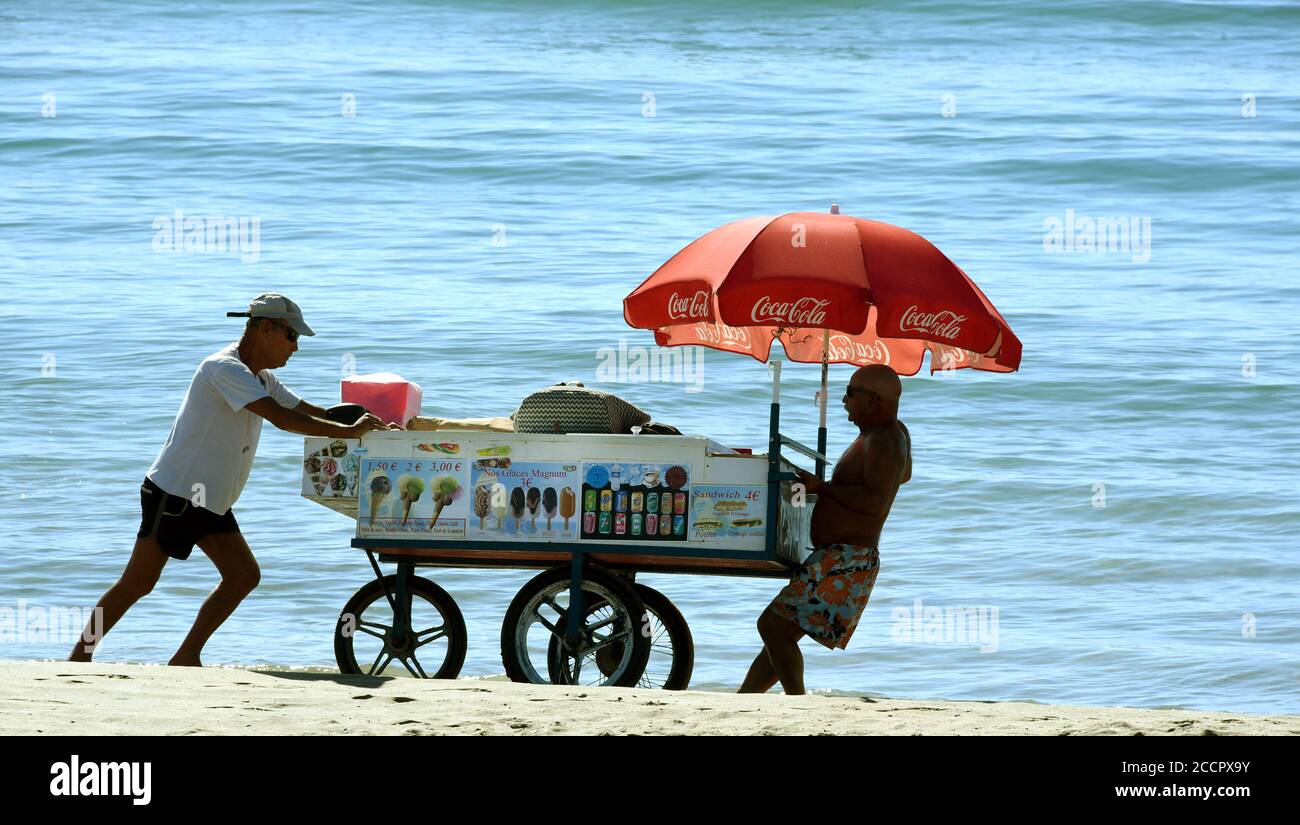 Marseillan, Frankreich. August 2020. Eisverkäufer schieben ihren Verkaufswagen am Strand in Marseillan Plage entlang. Quelle: Waltraud Grubitzsch/dpa-Zentralbild/ZB/dpa/Alamy Live News Stockfoto