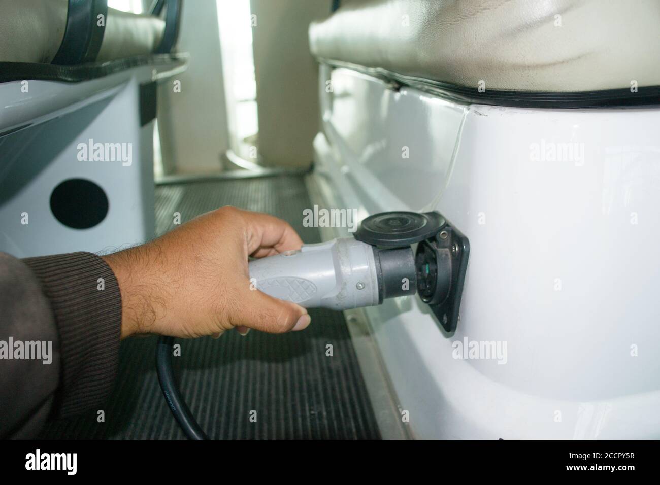 Hand hält elektrischen Stecker zu starten Laden Elektroauto. Transporttechnik Konzept Stockfoto