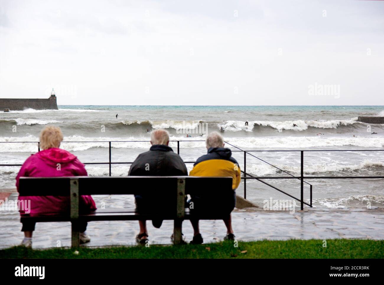 Alte Leute beobachten junge Surfer im Hafen von Collioure, Südfrankreich Stockfoto