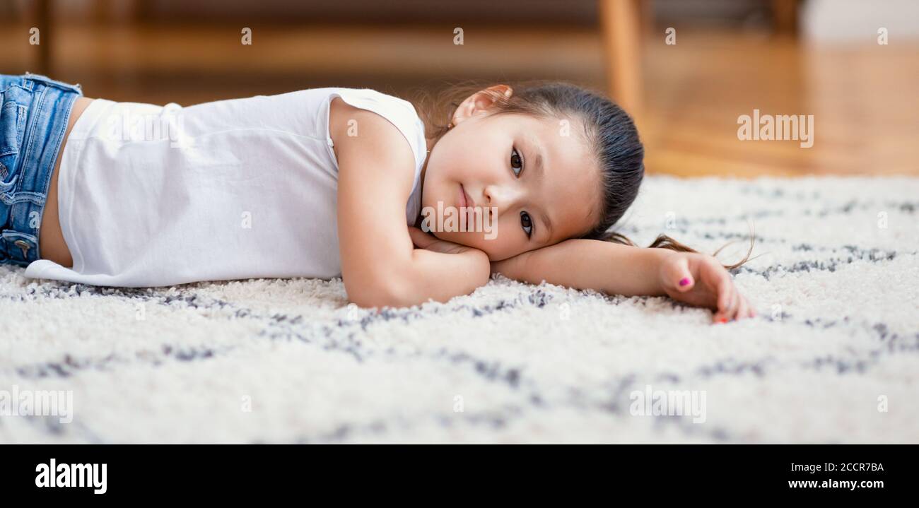 Gelangweilte Chinesische Kleine Mädchen Auf Dem Boden Liegen Zu Hause, Panorama Stockfoto
