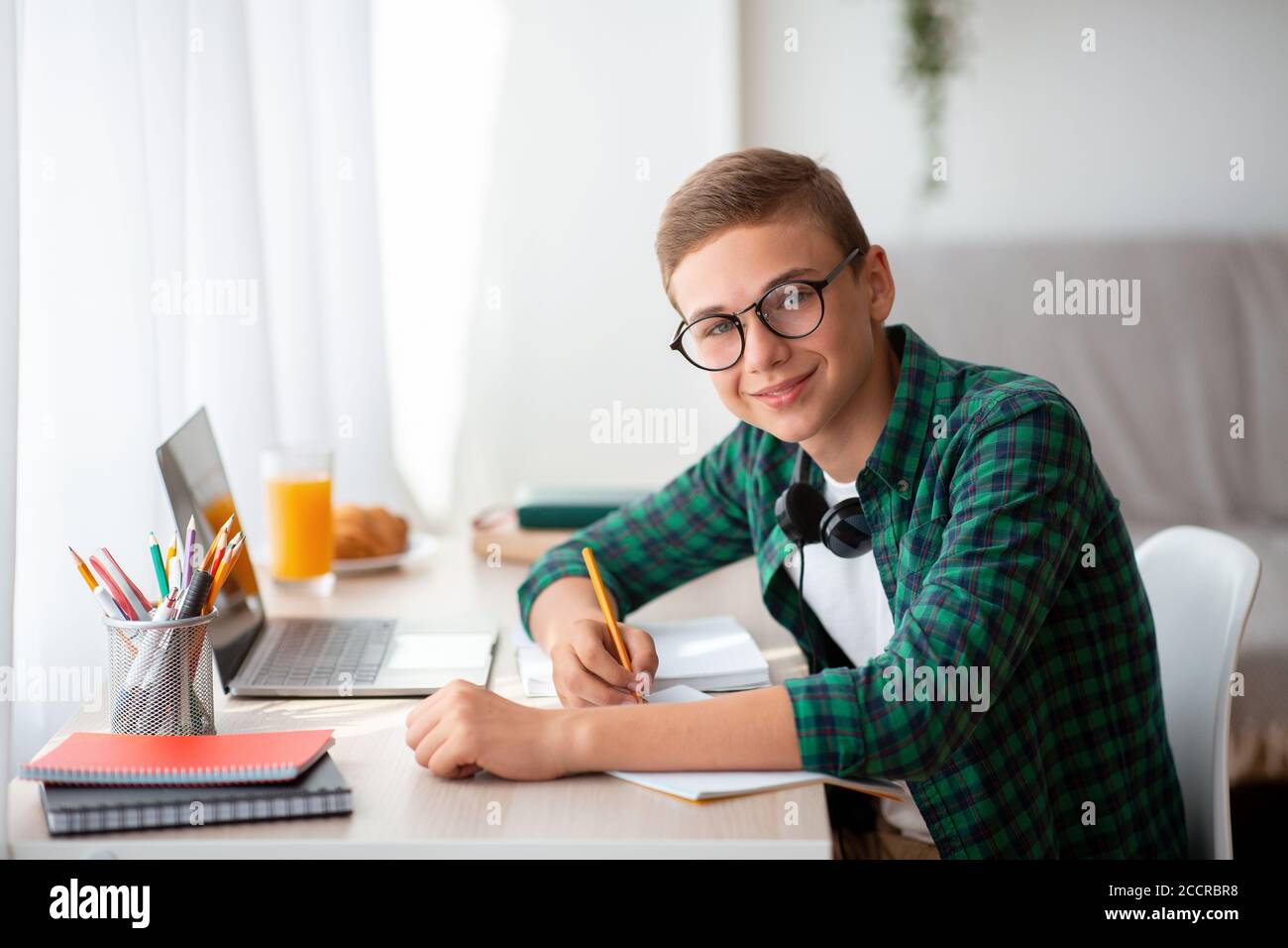 Glücklich teen Kerl tun Hausaufgaben zu Hause Stockfoto