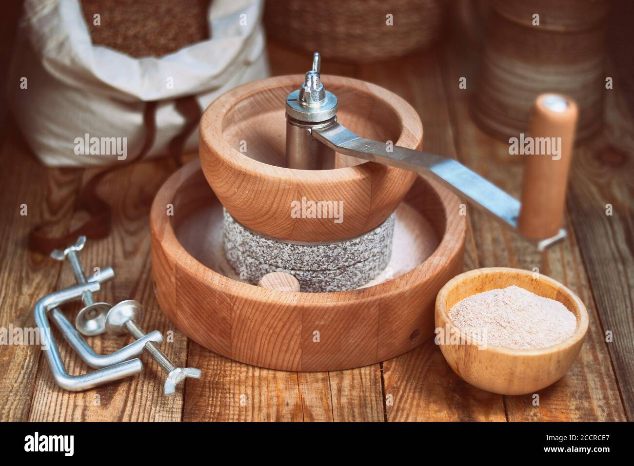 Getreidemühle - Manuelle Getreidemühle zum Handschleifen, auf einem Holztisch Stockfoto