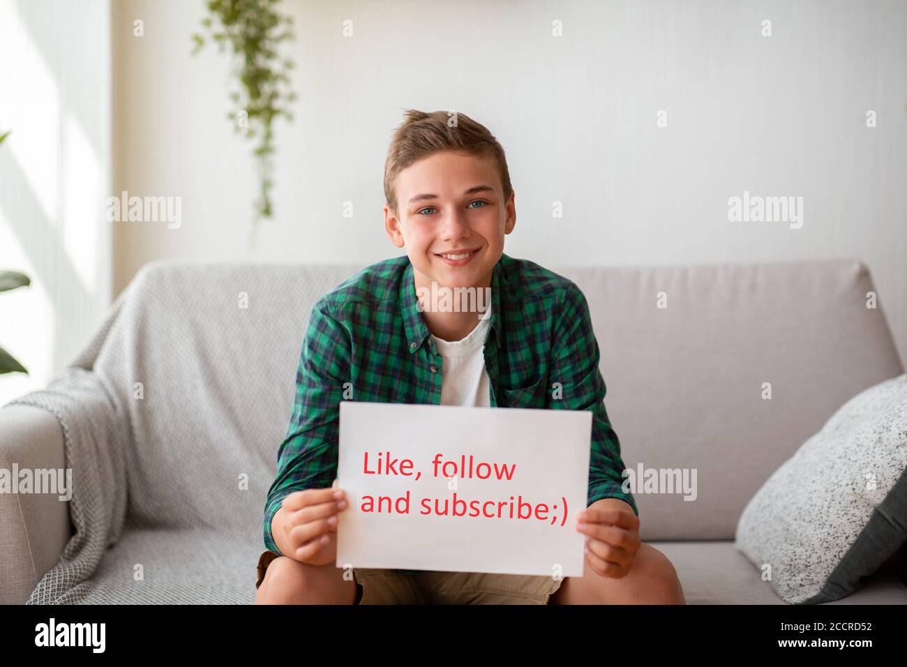 Teen blogger hält Plakat mit wie folgen subscribe Text Stockfoto