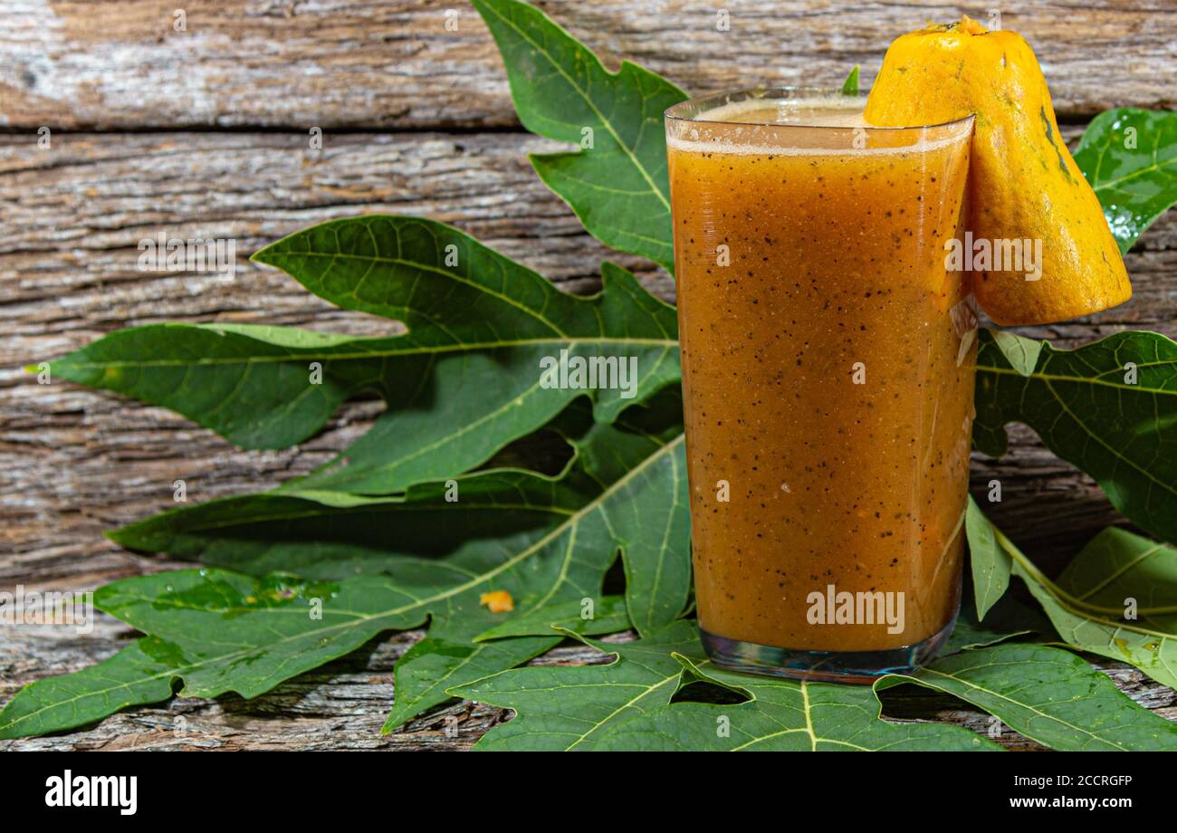 Papaya. Tropische Früchte. Auf einem hölzernen Hintergrund. Vorderansicht. Ein Glas Saft. Erfrischung. Detox-Diät. Morgendliche Fütterung. Darmregulation. Körper h Stockfoto