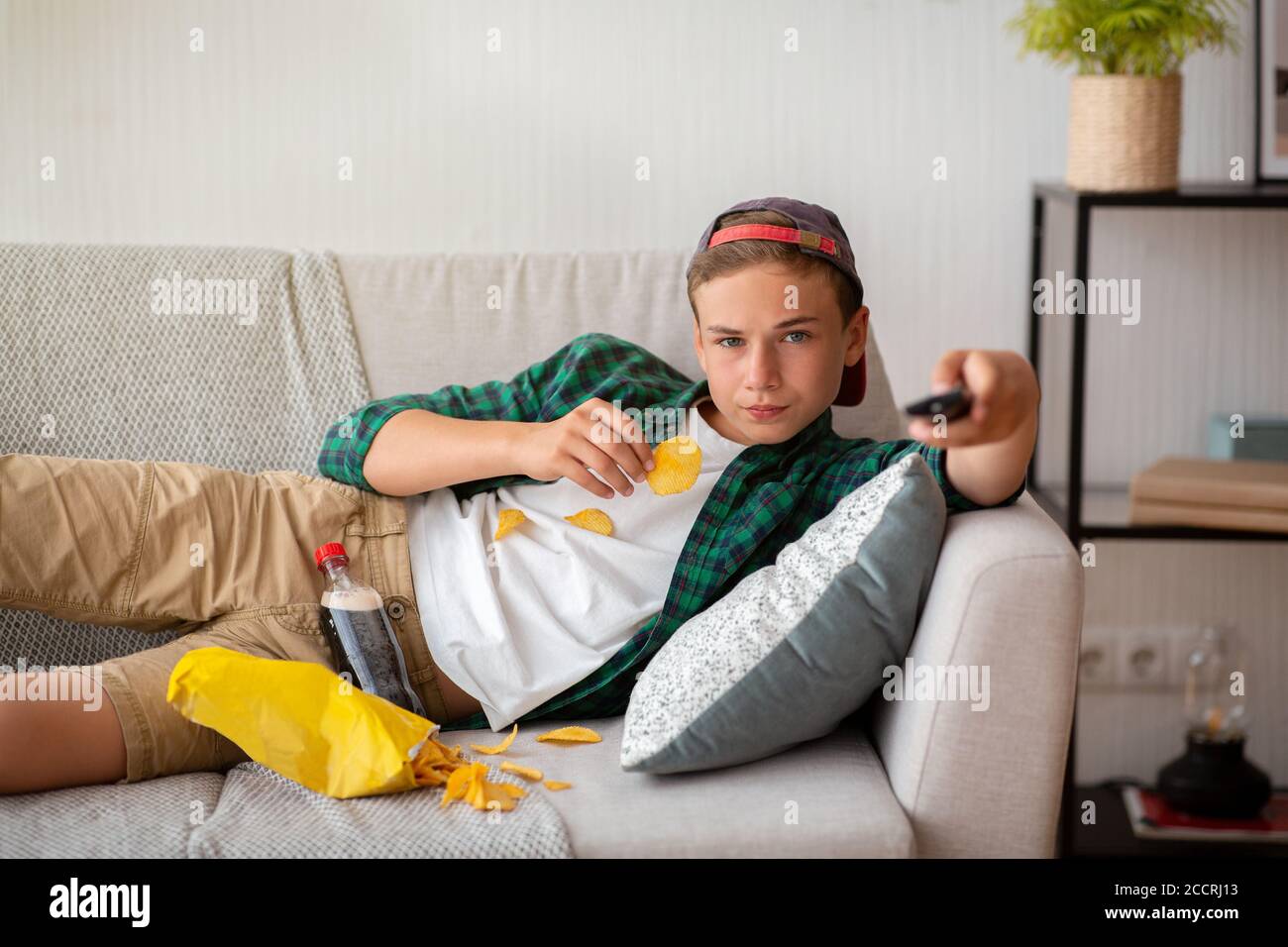 Teenager, die zu Hause ausruhen, Fernsehen und Snacks essen Stockfoto