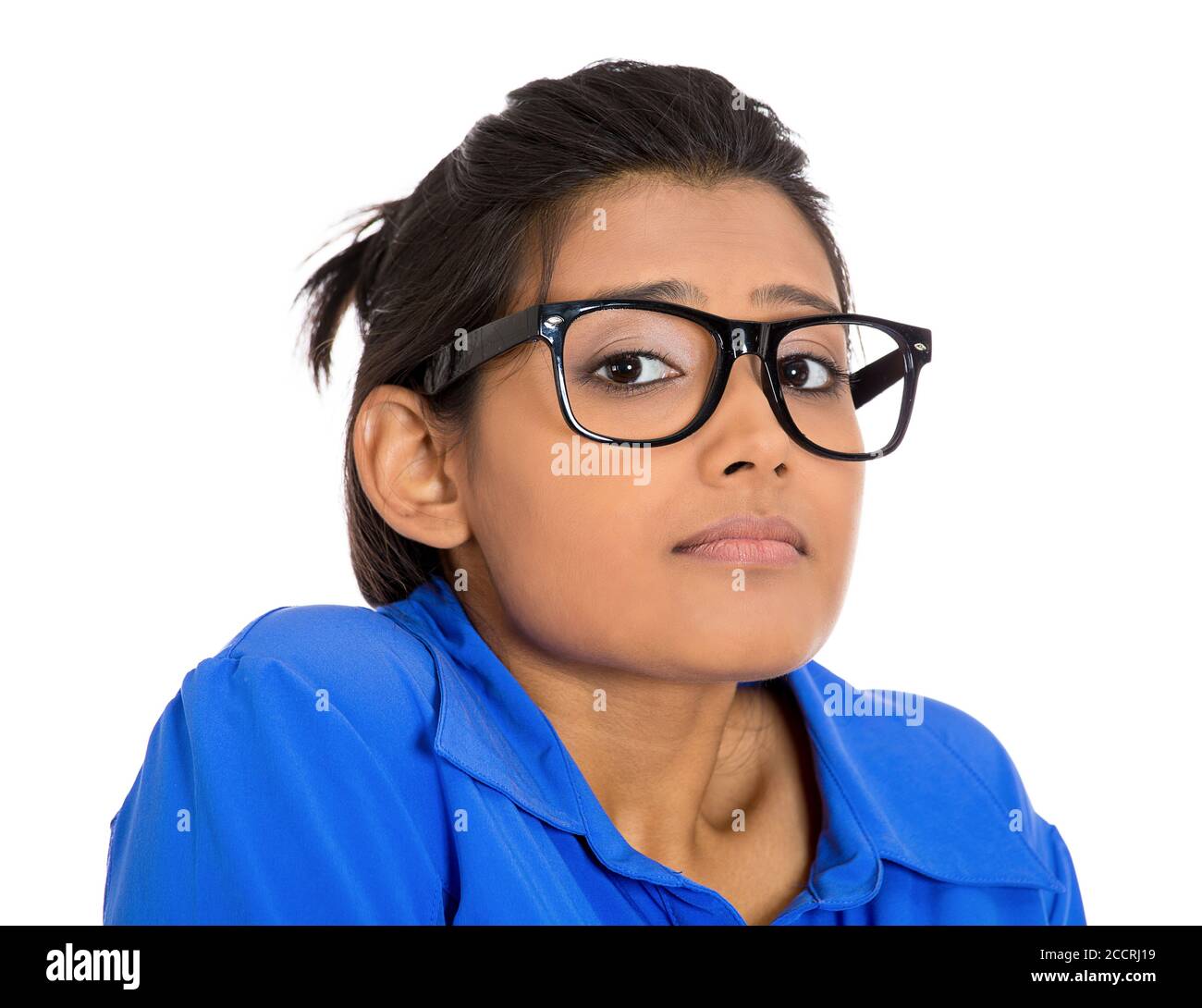 Nahaufnahme Porträt einer jungen nerdy aussehenden Frau mit großer Brille, sehr schüchtern und ängstlich, die Sie anschaut, isoliert auf weißem Hintergrund. Stockfoto