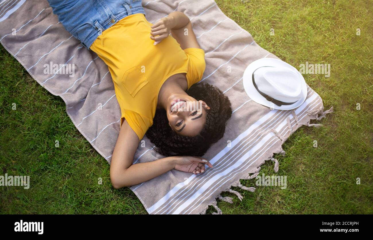 Draufsicht auf glückliche schwarze Mädchen auf Picknick-Decke entspannen Im Park Stockfoto