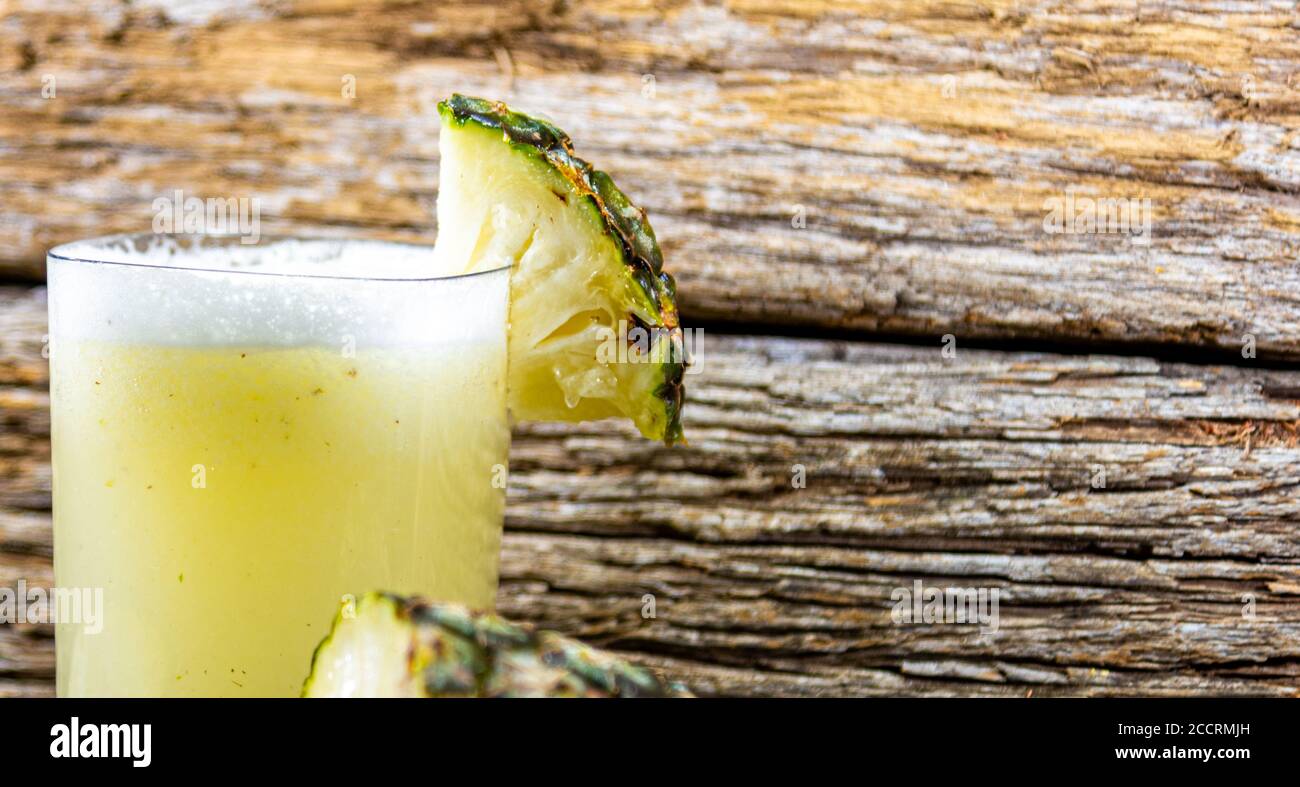 Ananas. Tropische Früchte. Auf einem hölzernen Hintergrund. Vorderansicht. Ein Glas Saft. Erfrischung. Detox-Diät. Morgendliche Fütterung. Darmregulation. Körper' Stockfoto