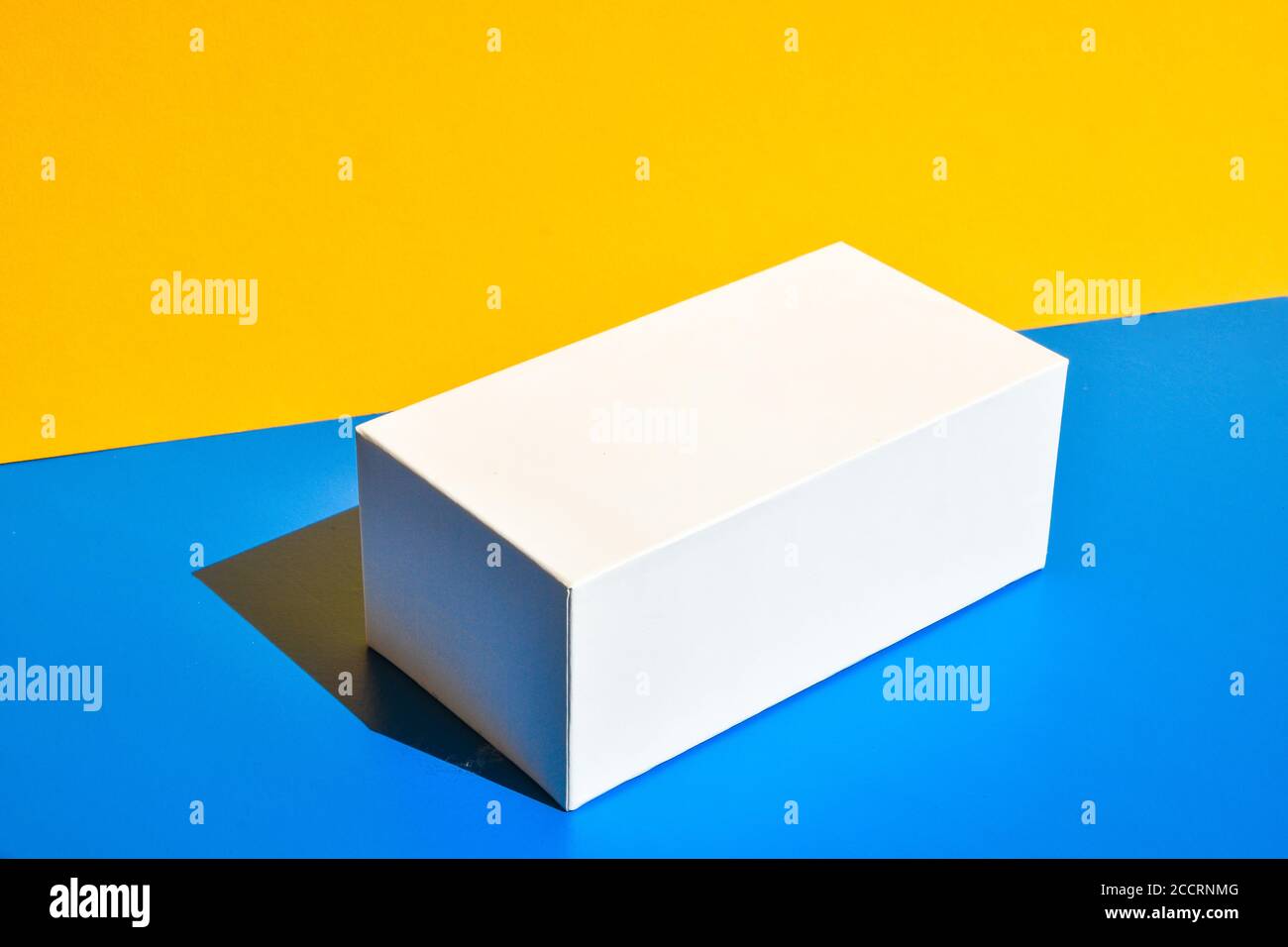 Weißes Feld. Modell der Drogenbox. Modell. Speicherplatz kopieren. Gelb und blau kreativen Minimalismus isometrischen Hintergrund Stockfoto