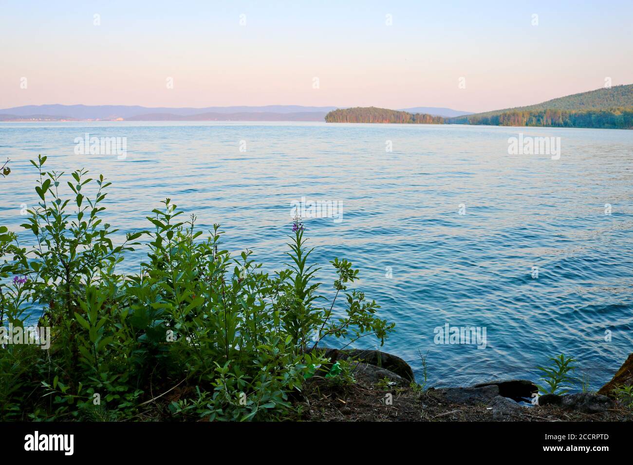 See im Abendlicht. Ruhiges, klares Wasser. Der reinste See Turgoyak, Russland. Stockfoto